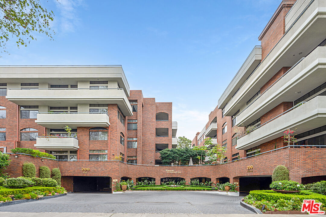 Brick-and-glass exterior of The Somerset at 200 N Swall Drive seen from the curved entry courtyard.
